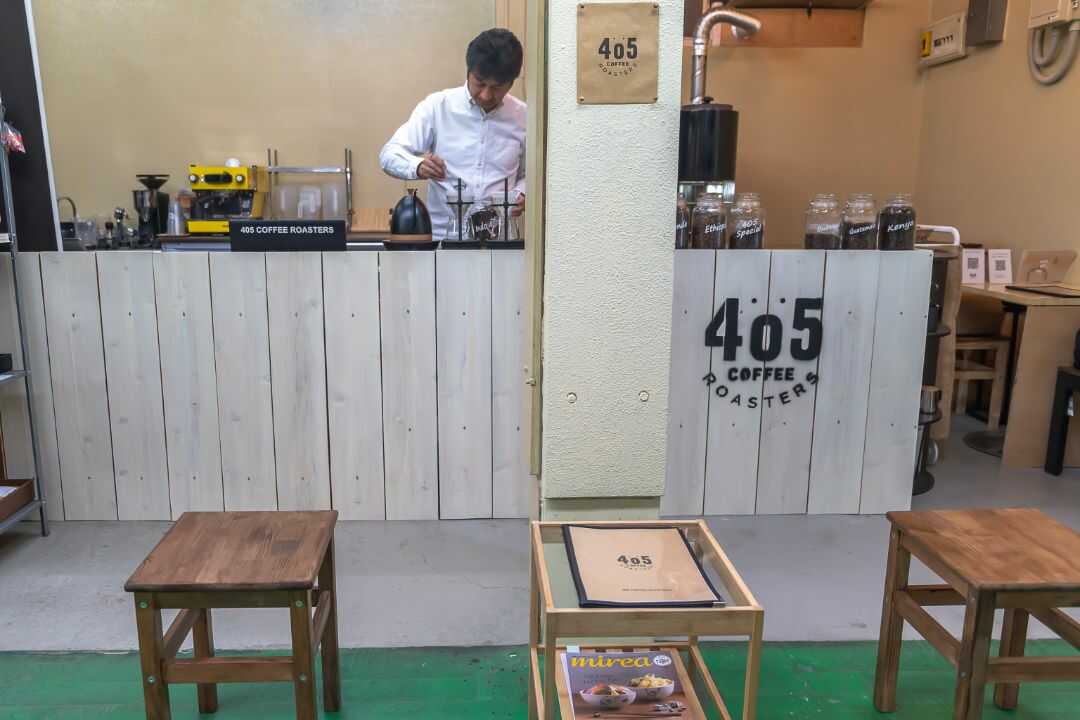 『405 コーヒーロースターズ』の店内でコーヒーを淹れるオーナー