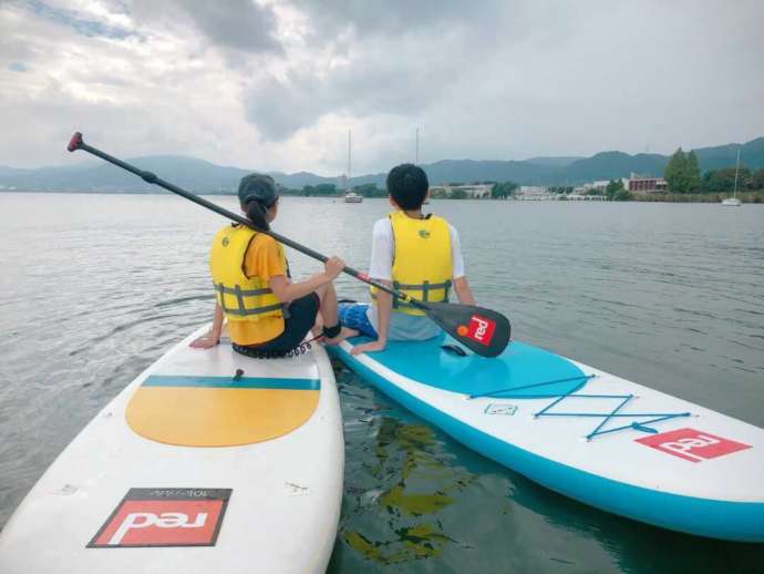 水上さんぽ滋賀のSUPボード上でくつろぐカップルの後ろ姿