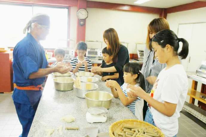 広島県福山市にある「鞆の浦 鯛匠の郷」でちくわを握る職人とお客さん