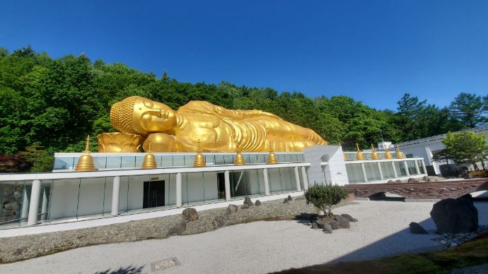 境内の日本庭園から望む「舎利山 佛願寺」の涅槃大仏