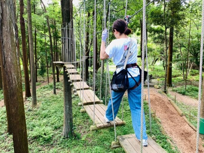 樹上アスレチックを楽しむ女性