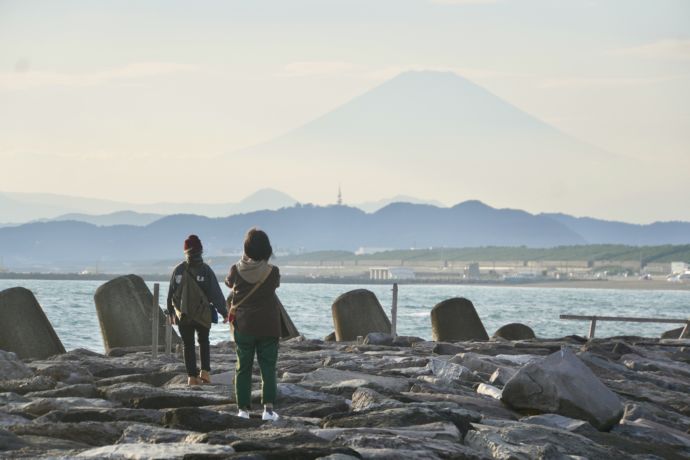 茅ヶ崎市の海岸から富士山を眺める人たちの図