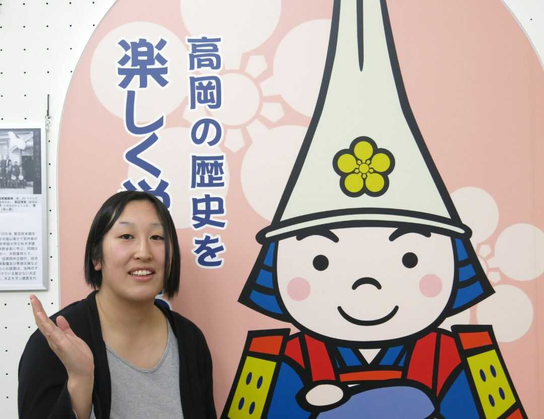 高岡市マスコットキャラクター「利長くん」と共に館内を紹介する宇川さん