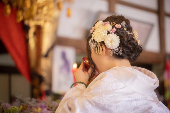 曹洞宗 永松山 龍泉寺の仏前結婚式で盃を傾ける新婦