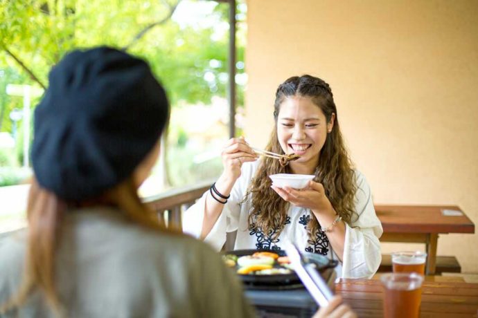 堺・緑のミュージアム ハーベストの丘内のバーベキューレストランで食事をする女性