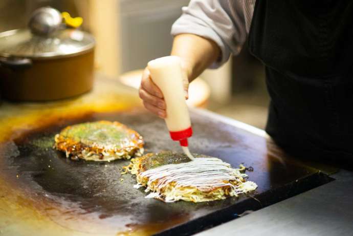 府中市のソウルフードである府中焼きを焼いている写真