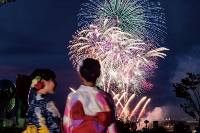 ふくろい遠州の花火}」を見る女性ふたりの後ろ姿