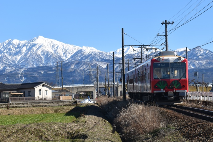 立山連峰をバックに走る電車