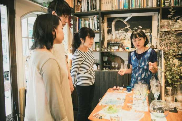 ちいさな硝子の本の博物館で館長から説明を受けるお客さん