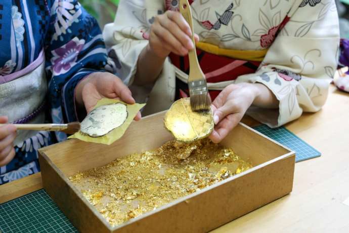 「金銀箔工芸さくだ」本店の「金箔貼り体験」で小箱を制作中