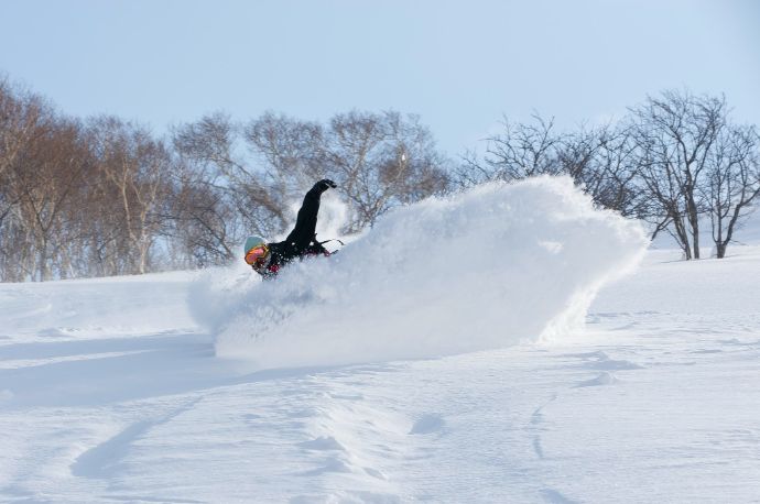 ニセコHANAZONOスキー場でスノーボードを楽しむ男性