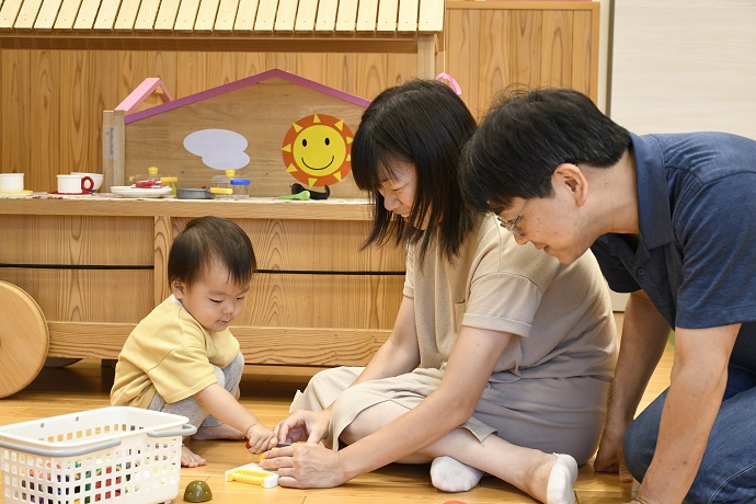 ブロックで遊ぶ幼児と両親