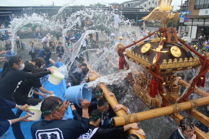 水かけ神輿で沿道から水をかけている様子