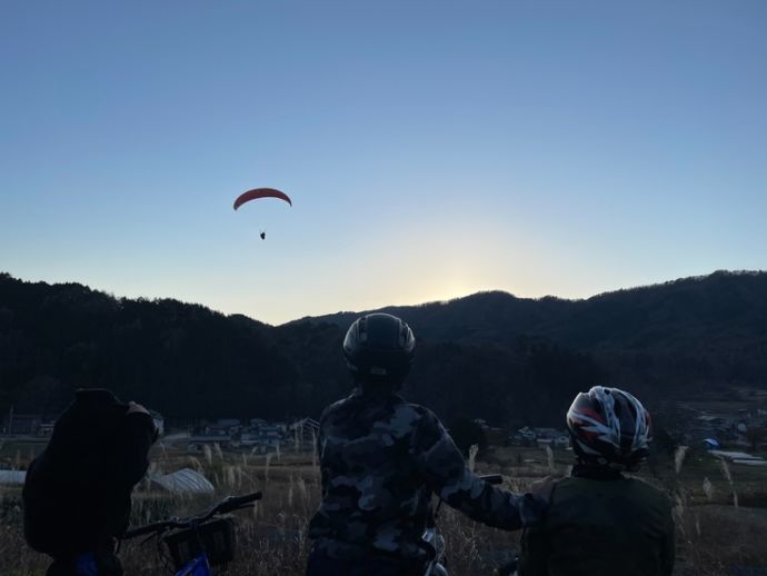 高嶺山の上にパラグライダーをする人影