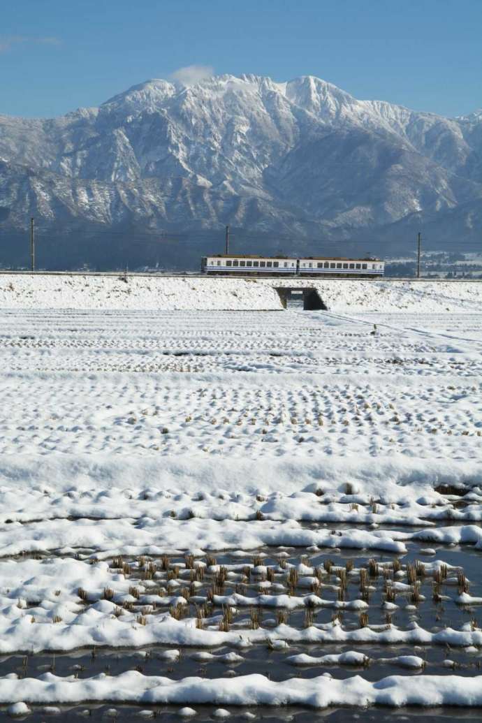 ほくほく線と八海山の冬景色