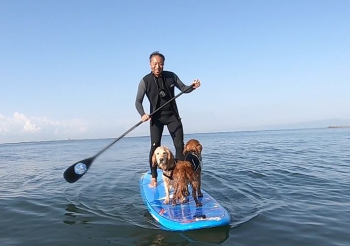 神奈川県茅ヶ崎市の「Hosoii Surf&Sports」で犬とSUPをしている男性