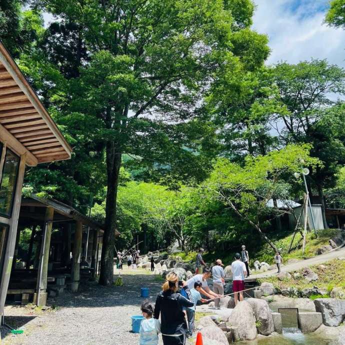 釣り場で釣りを楽しむ家族連れやカップルたち