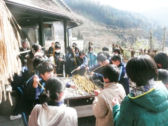 蒸し剥ぎ小屋横のテラスで体験をしている様子