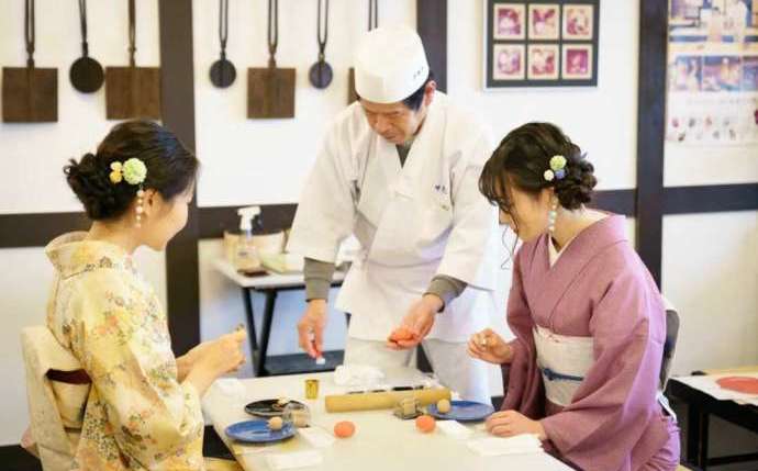 京都府京都市にある菓匠「甘春堂 嵯峨野店」で職人が和菓子作りのお手本を見せる様子