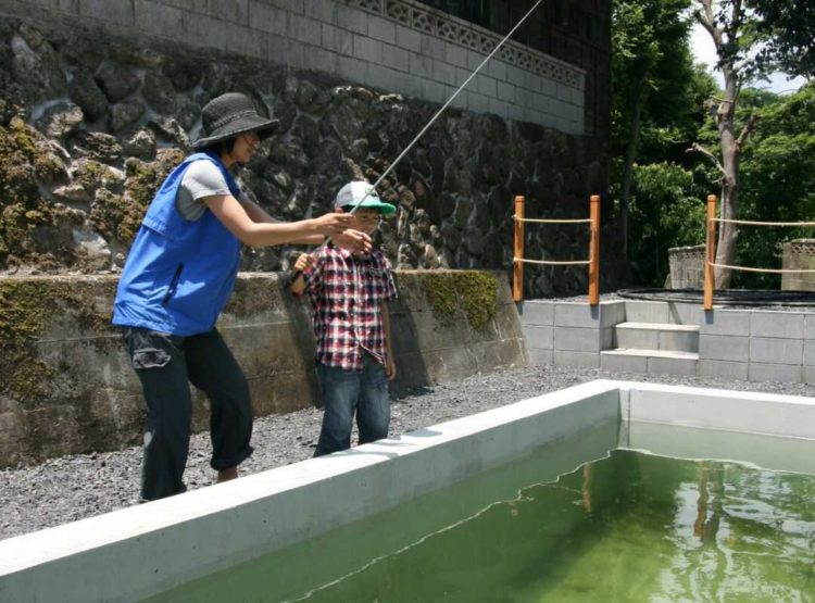 ケニーズ・ファミリー・ビレッジ/オートキャンプ場で釣りをしている親子