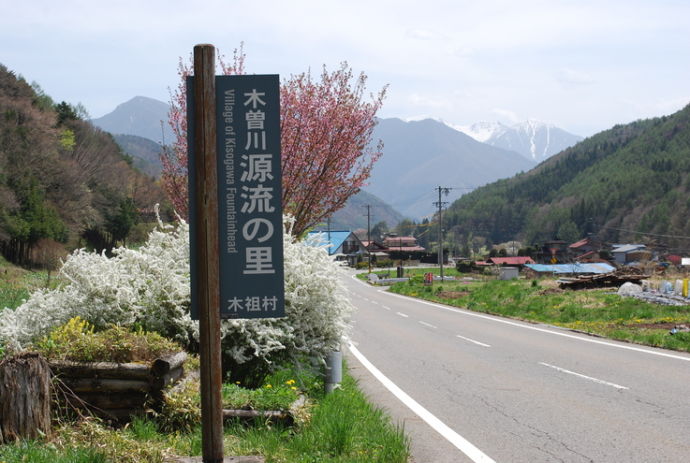 「木曽川源流の里」と書かれた看板と、木祖村入り口の風景