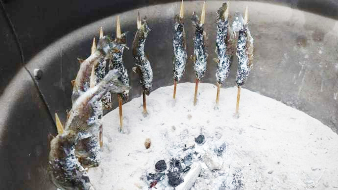 釣れた魚を炭火で焼き上げている写真