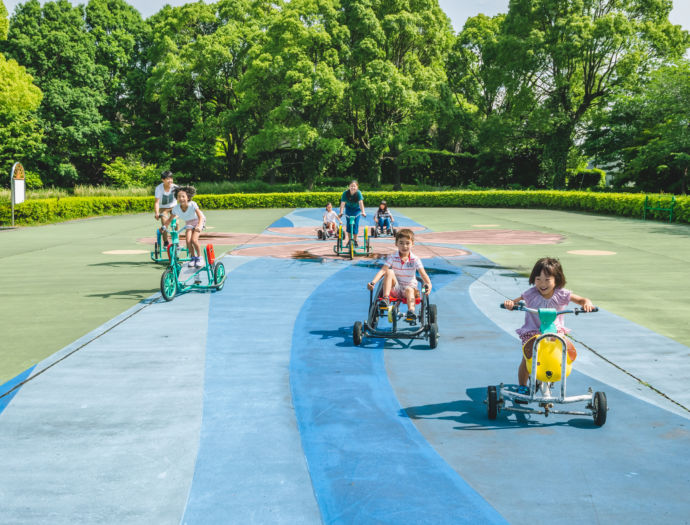 久留米サイクルファミリーパークで、おもしろ自転車に乗る子どもたちの図