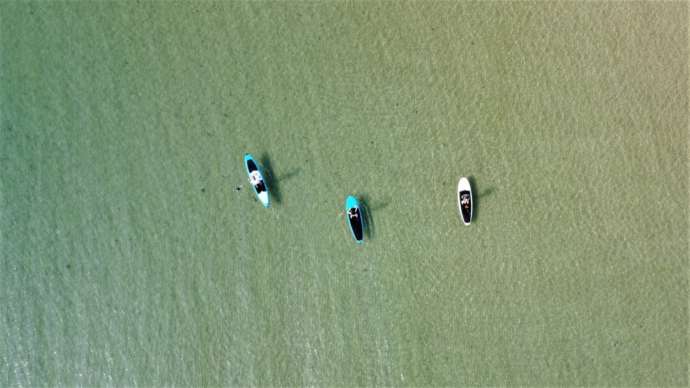 夕日ヶ浦海岸にある京丹後135°EASTでSUPを楽しむ人々