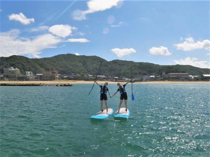 夕日ヶ浦海岸にある京丹後135°EASTでSUPに乗る人々