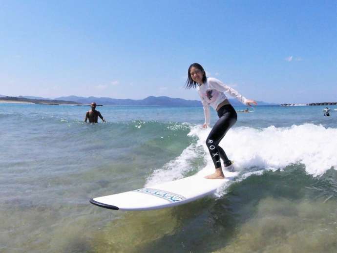 夕日ヶ浦海岸にある京丹後135°EASTでサーフィンのレッスンを受ける女性