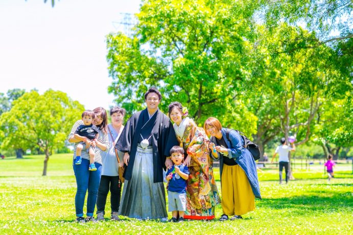 鶴見緑地公園で笑顔の新郎新婦と家族