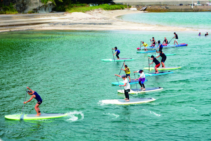 水俣市の湯の児海水浴場でSUPを体験する人々