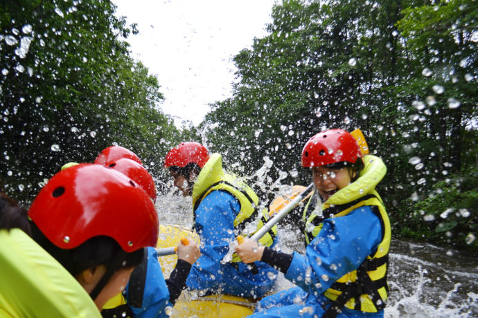 ラフティングで水しぶきを浴びる人々