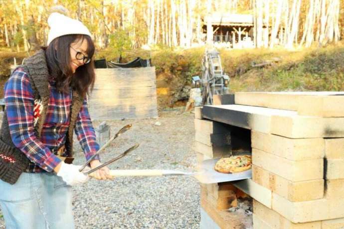 焼き上がったピザを取り出す様子