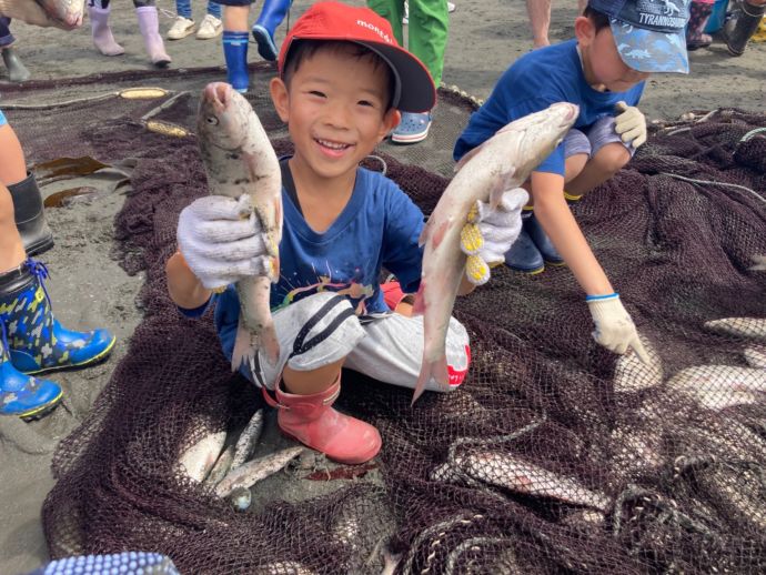 むかわ町の「むかこみゅ」の様子。地引き網でつかまえた魚を持つ子ども