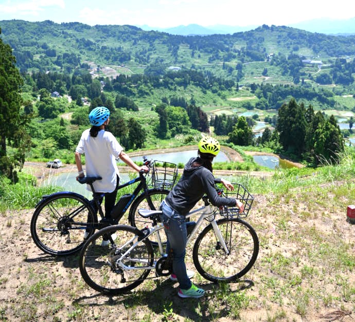 やまこし復興交流館おらたるのレンタサイクルを利用して山古志の棚田を散策する様子