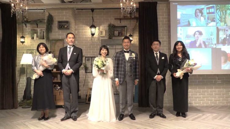 ネオフラッグのオンライン結婚式で写真撮影してもらっているご夫婦とご両親