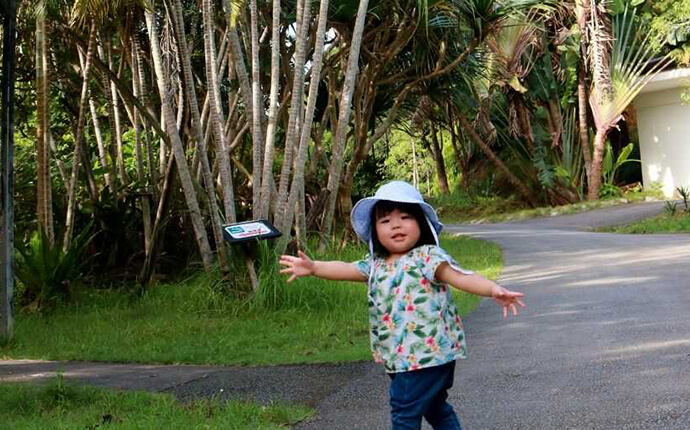 ネオパークオキナワの熱帯の植物と写真を撮る少女