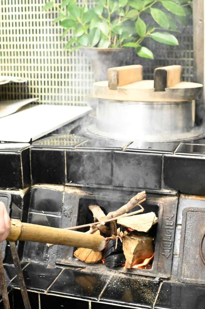 かまどでご飯を炊く様子の写真