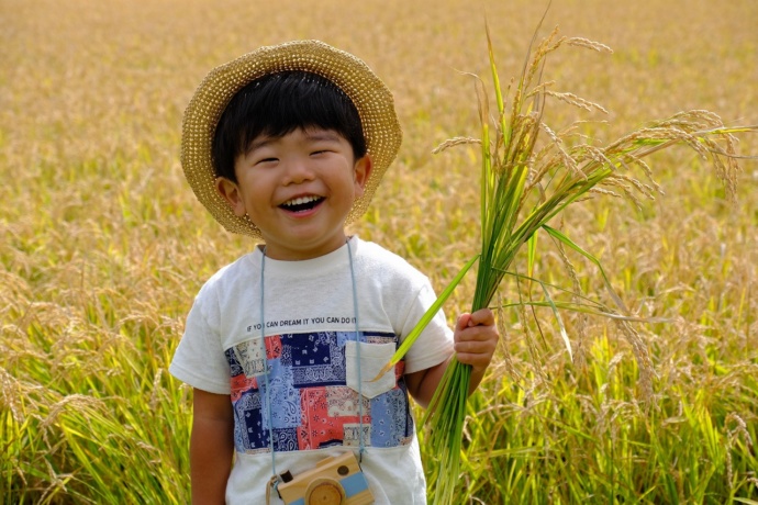 沼田町産の米を持つ子ども