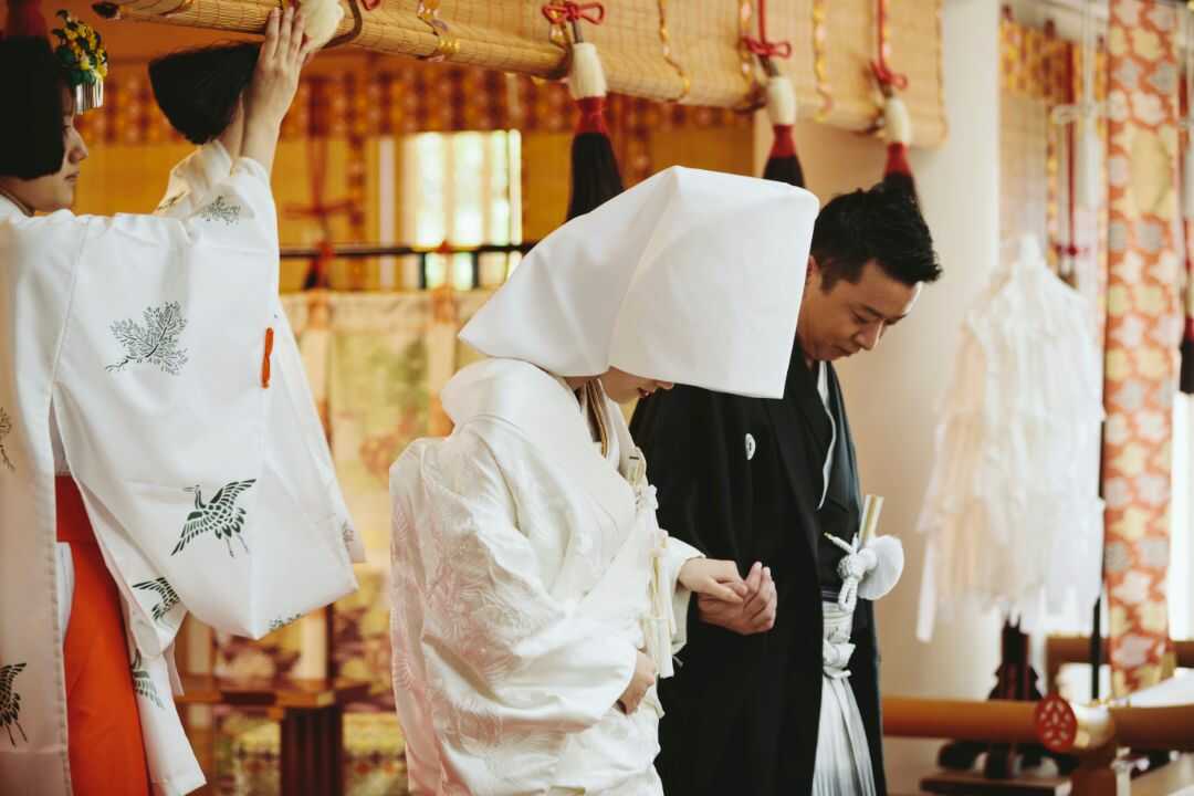 岡山神社の神前式で深々とお辞儀をする新郎新婦の姿