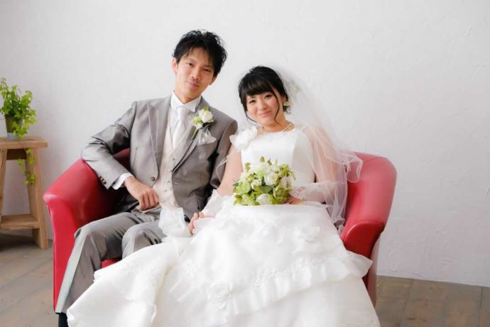 フォトシーズンのスタジオで、結婚写真を撮る2人