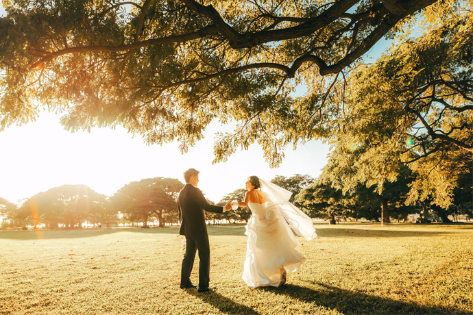 夕日をバックに新郎が新婦をお姫様抱っこして撮影した写真