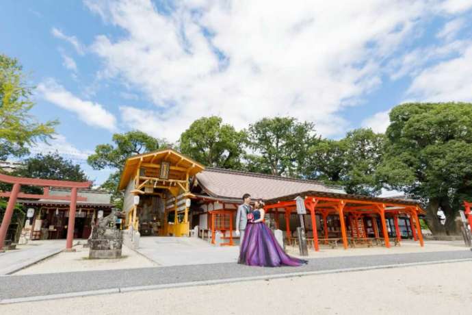 佐嘉神社の境内でロケーション撮影をしている洋装の新郎新婦