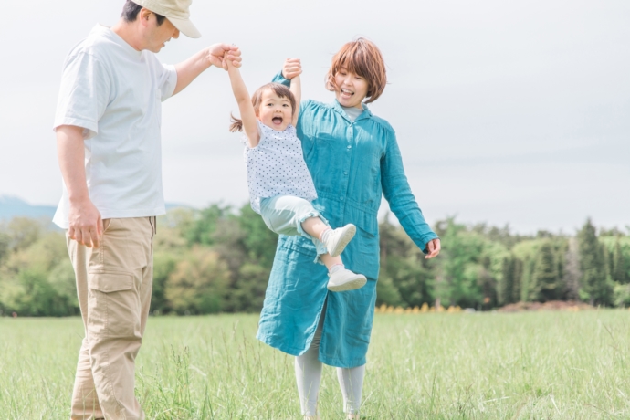 手つなぎブランコをする家族