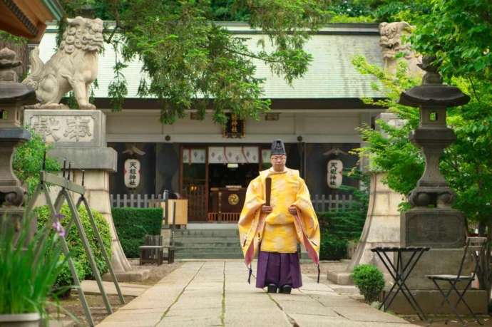 下神明天祖神社の本殿の前に佇む神職