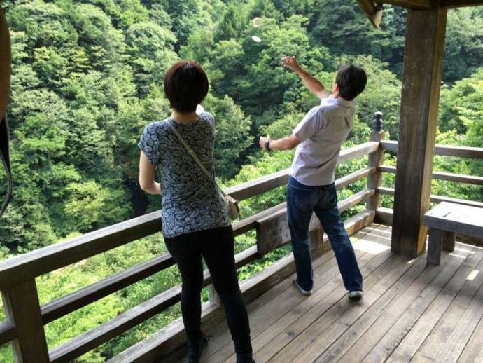 「暮白の滝」の滝見台から行う「皿投げ祈願」（夏季）