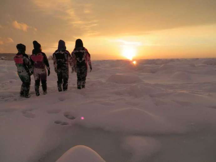 シンラの流氷ウォーク®で夕陽を見ている様子