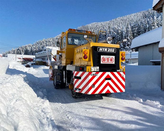 山形県庄内町の雪道を走る除雪車