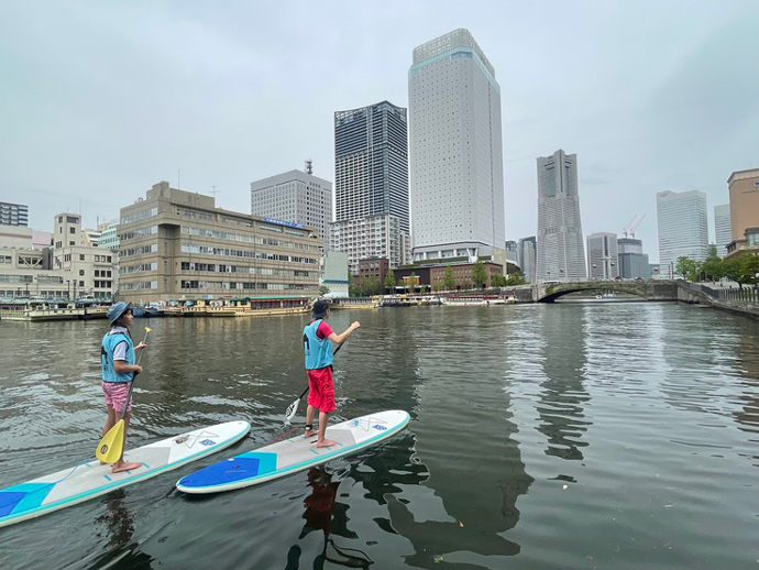 水辺荘のSUP体験ツアーに参加中のカップル（大岡川の河口付近）